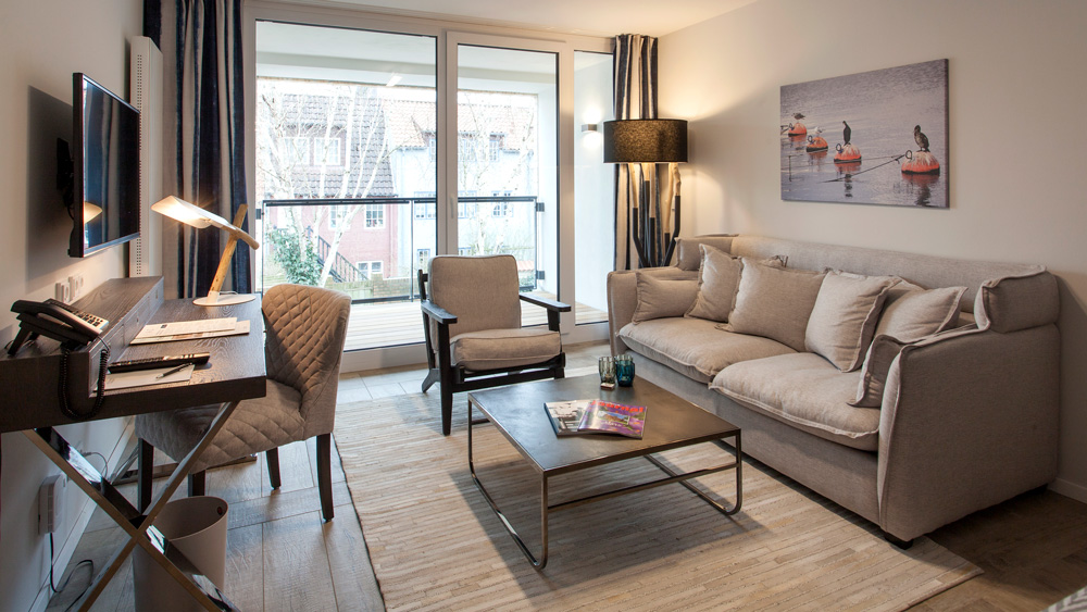 Stilvolle Suite in einem Hotel mit Sofa, Schreibtisch und Fernseher